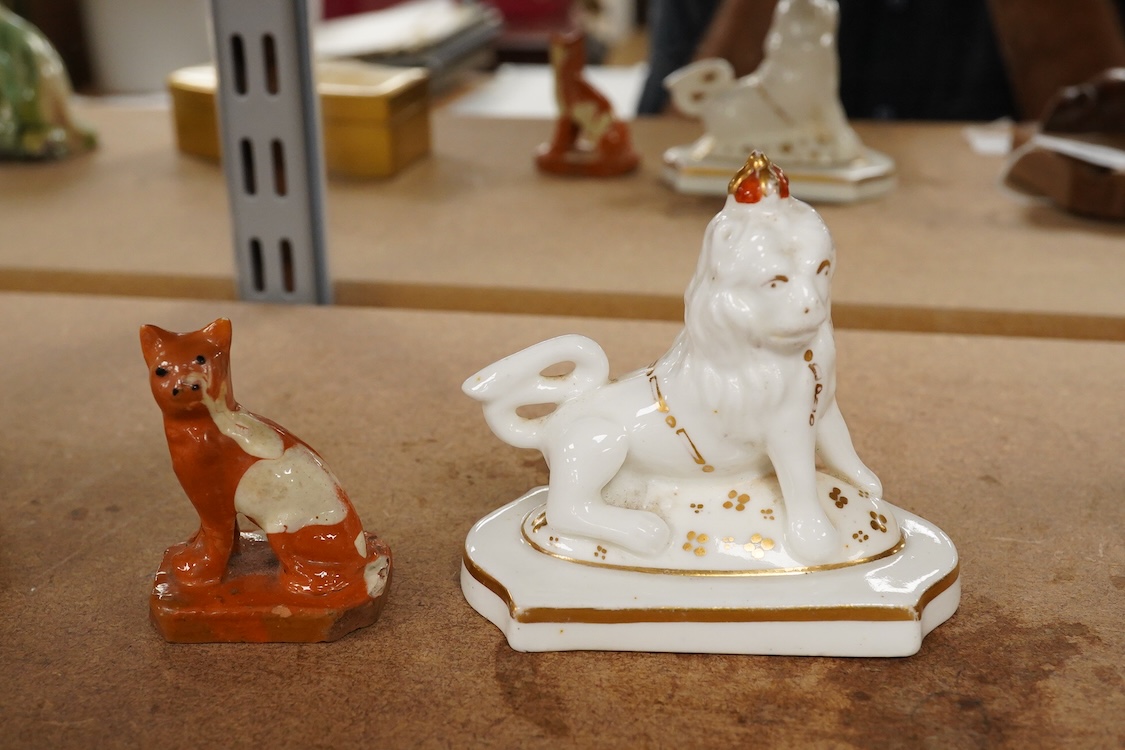 A Staffordshire lion with crown, c.1830-50 and a Staffordshire slipware cat, largest 8.5cm high (2)